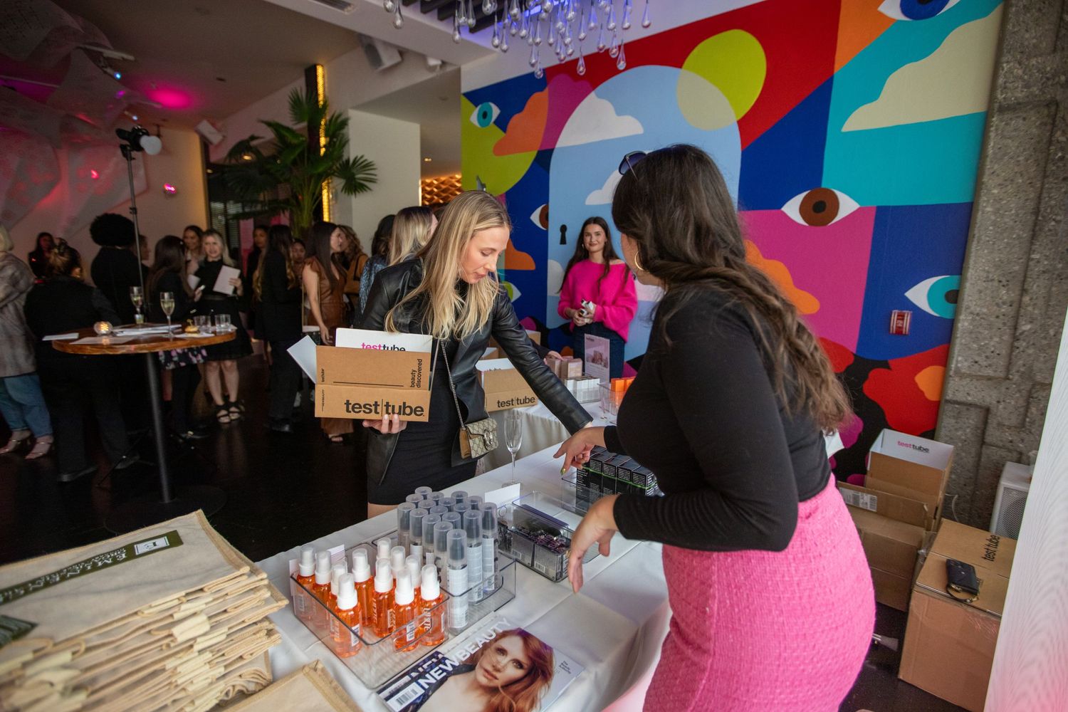 Beauty and cosmetics vendors display products at a colorful pop-up marketplace event.