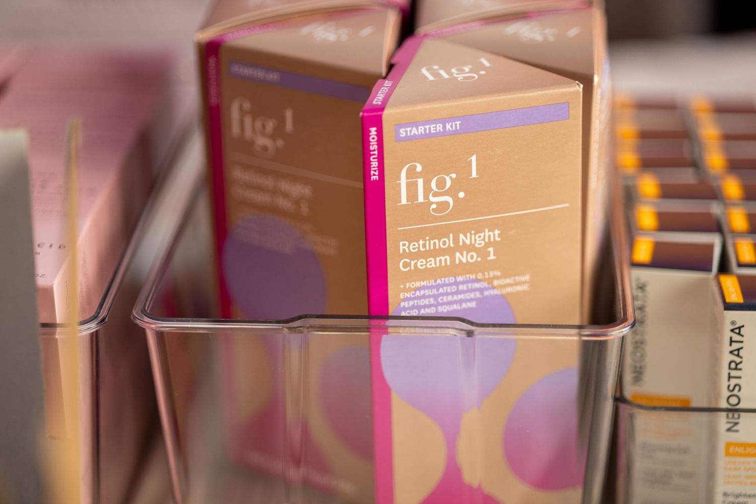 Pink and brown Fig 1 branded product boxes arranged in retail display.