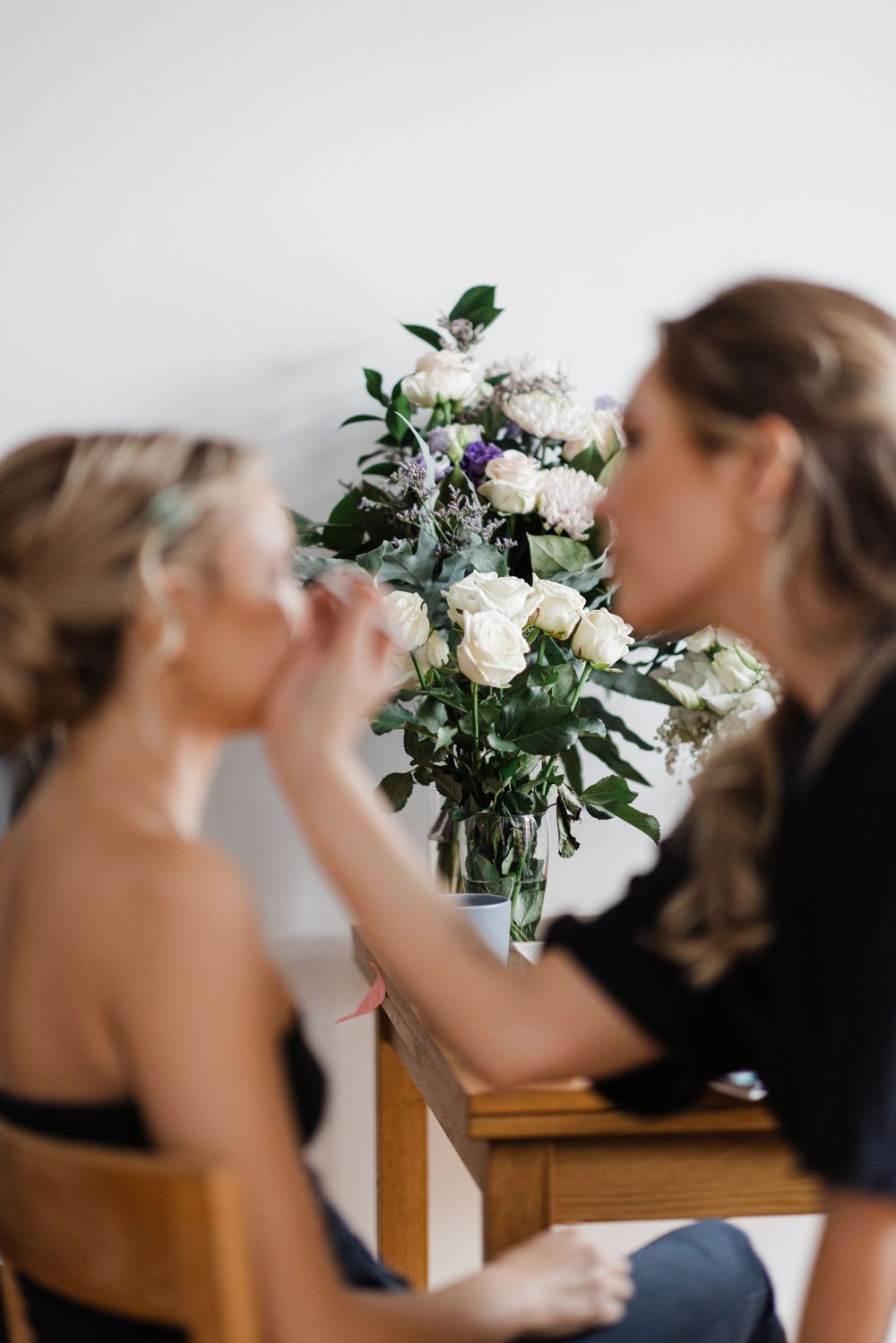 A fresh white and purple floral arrangement in a glass vase.