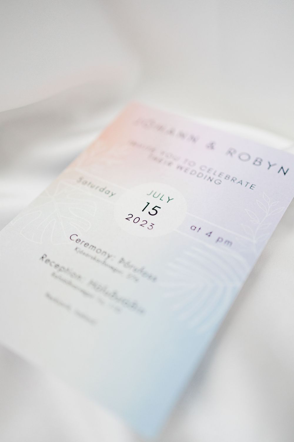 Wedding invitation with minimal design showing date details in soft focus.