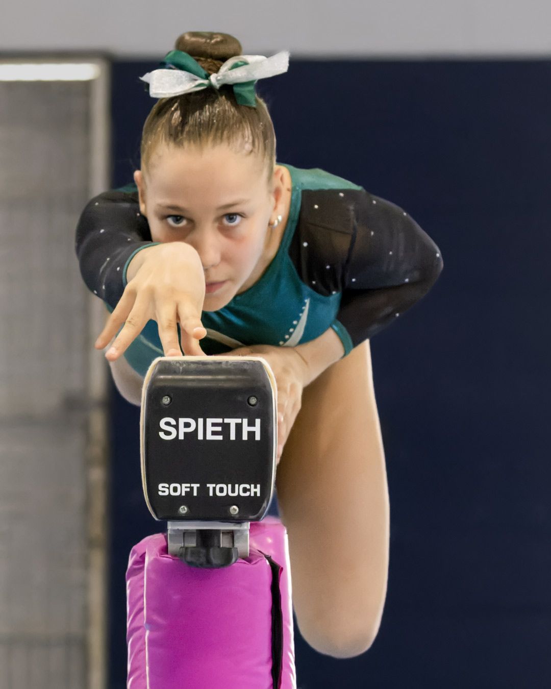 Nick Wigmore Gymnastics Photography: Young girl gracefully balancing on gymnastics beam.