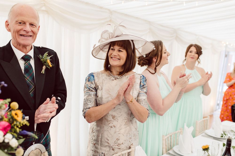 Guests enjoying a lively celebration at an elegant wedding reception with white decor.
