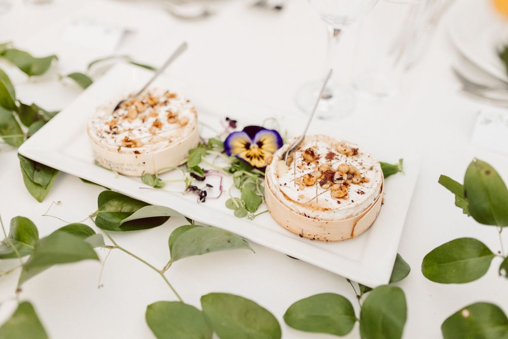 Elegant table settings with floral arrangements and greenery at a wedding reception.