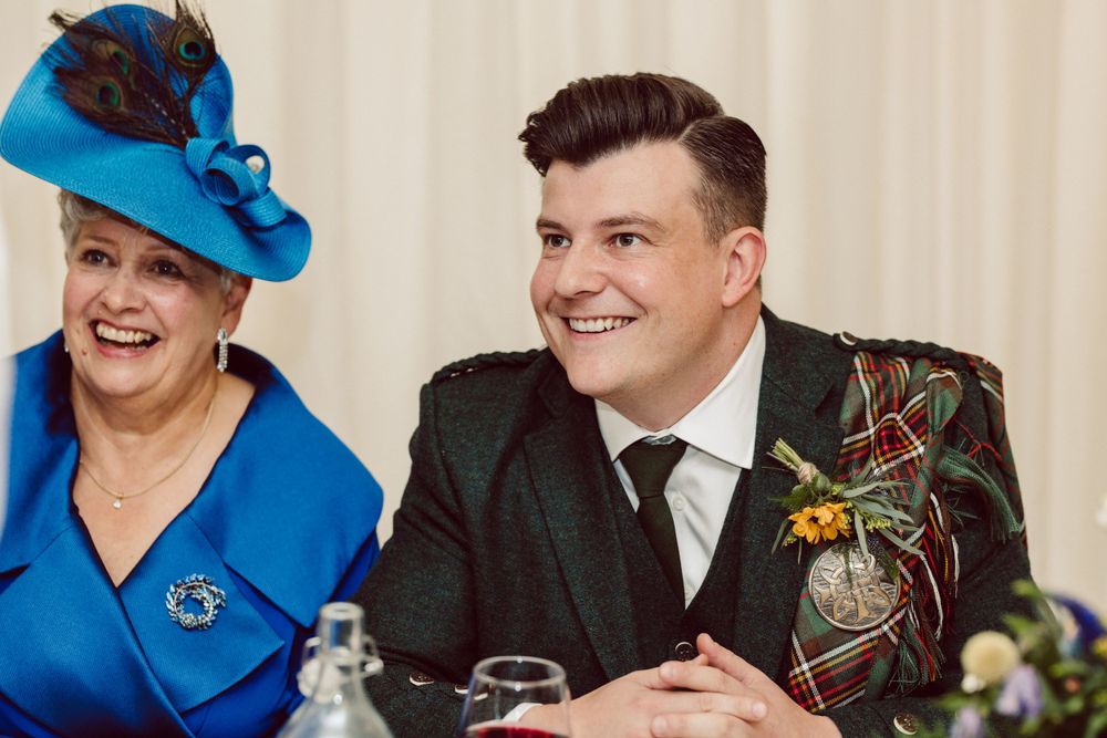 Wedding reception guests in formal attire and bright blue accessories enjoying the celebration.