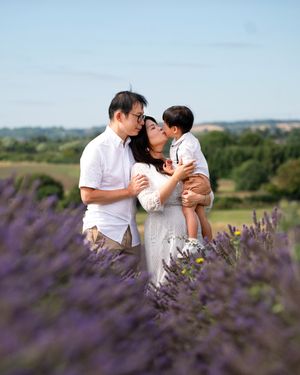 A family sharing an intimate moment together in a blooming lavender field on a sunny summer day.