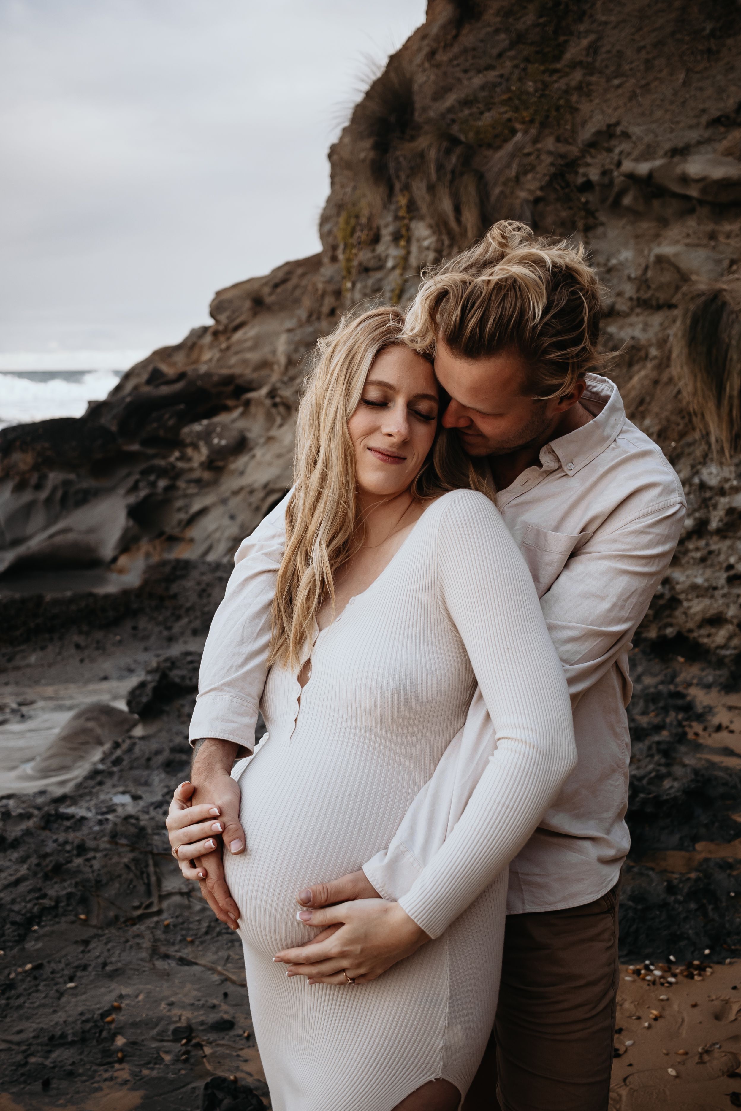 A couple hugging pregnant belly.