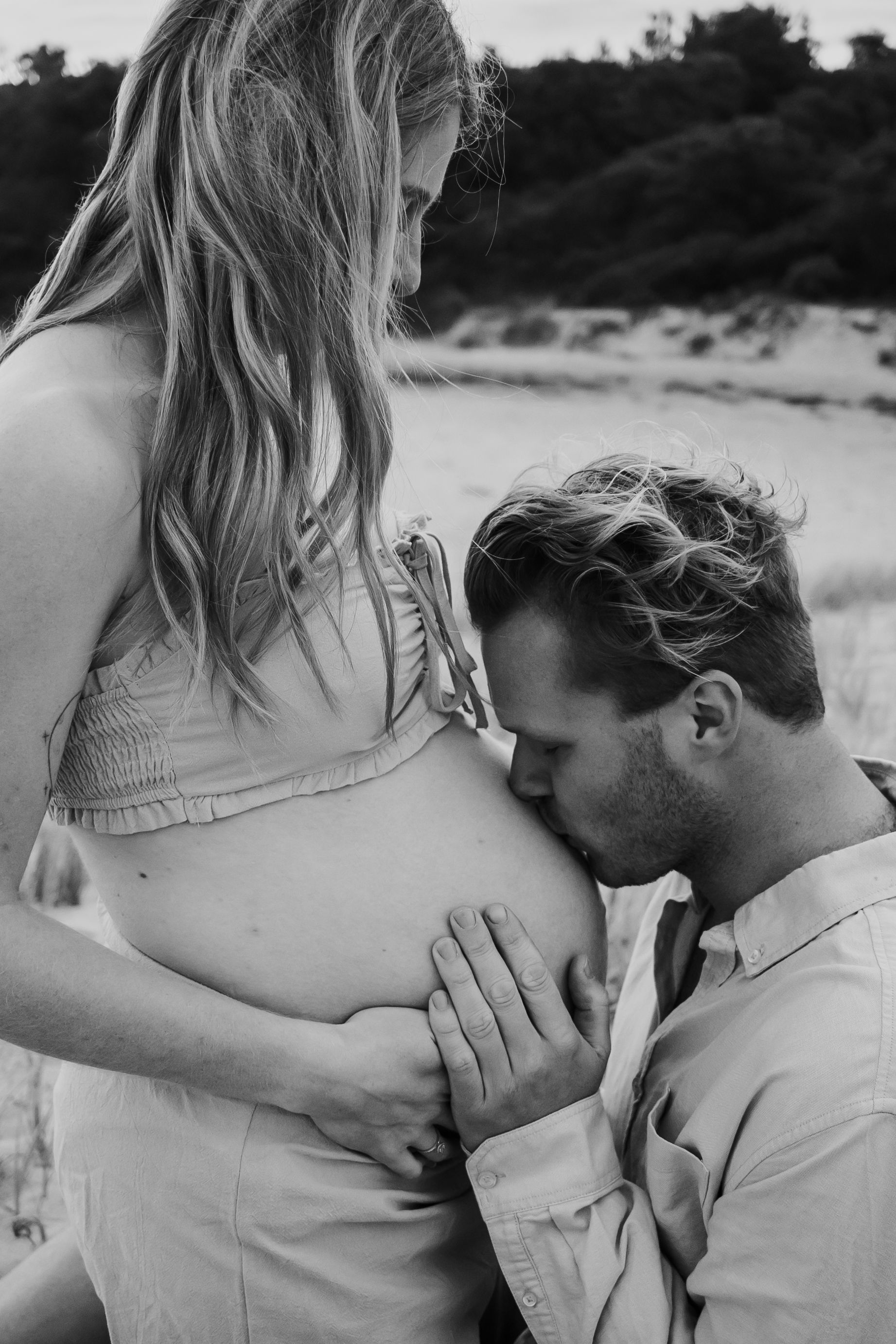 Dad kissing partner's pregnant belly.