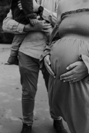Cropped photo of pregnant belly with dad and son.