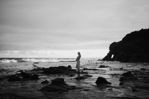 Wide shot of pregnant woman at the beach.