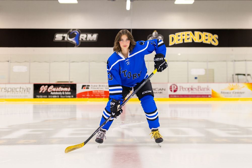 Senior girl in her hockey uniform at the ice rink in Sioux Center