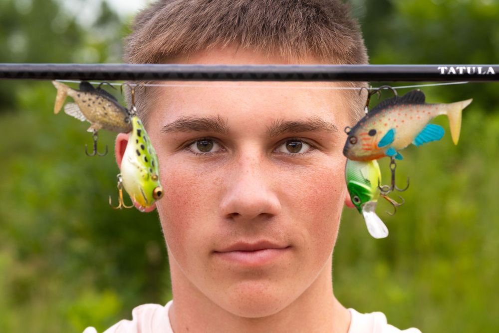 Senior boy posing with his fishing pole and lures in Sergeant Bluff