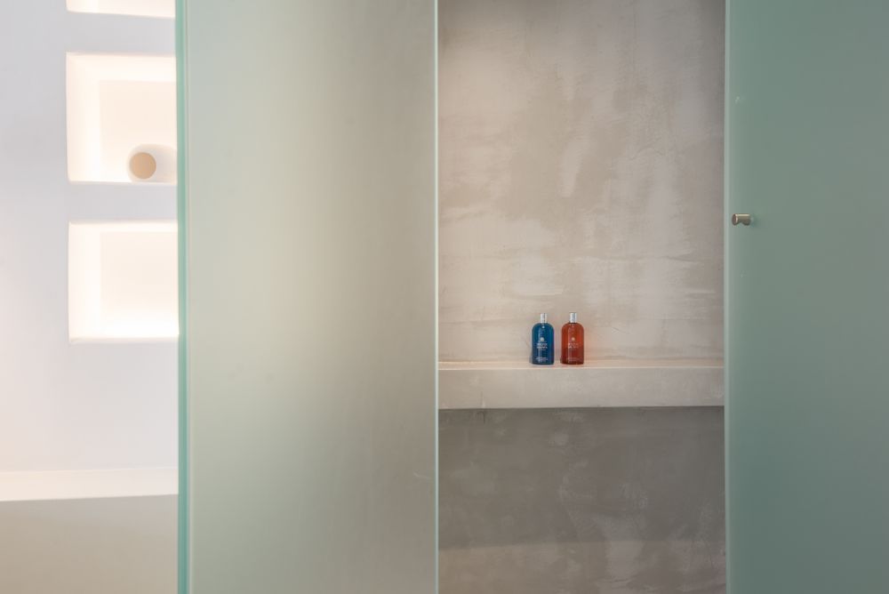Minimalist closet space with frosted glass panels and colorful decorative bottles.