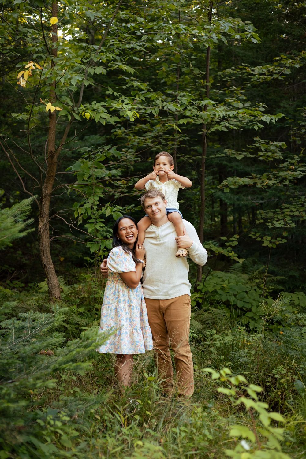A joyful outdoor family moment captured in a lush green forest setting.