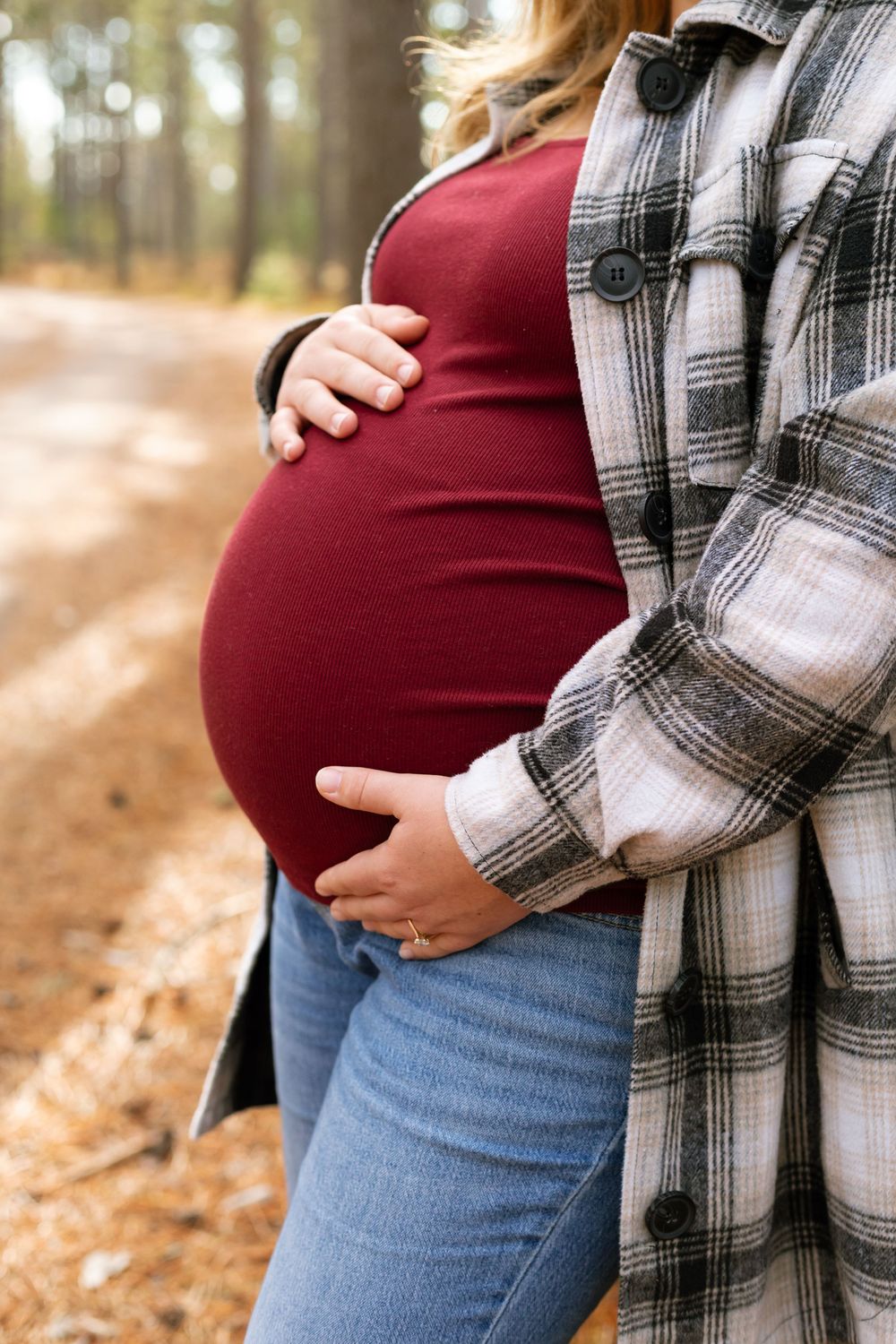 A series of pregnancy progression photos showing a growing baby bump with a plaid flannel shirt and jeans in autumn.