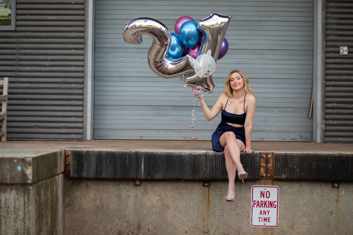 Creative dance poses against industrial wall with balloon props.