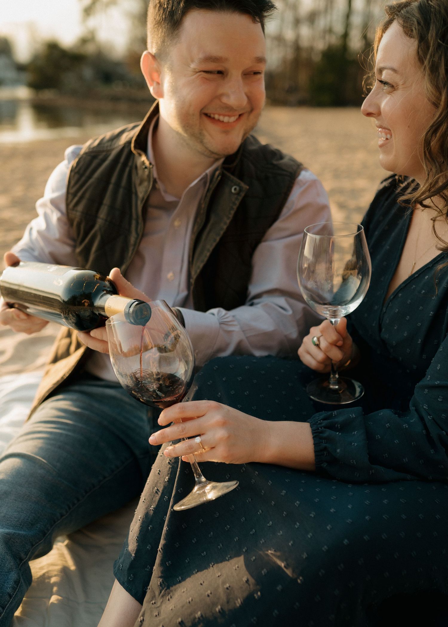 Couple enjoying wine together outdoors during golden hour sunset during Charlotte engagement session