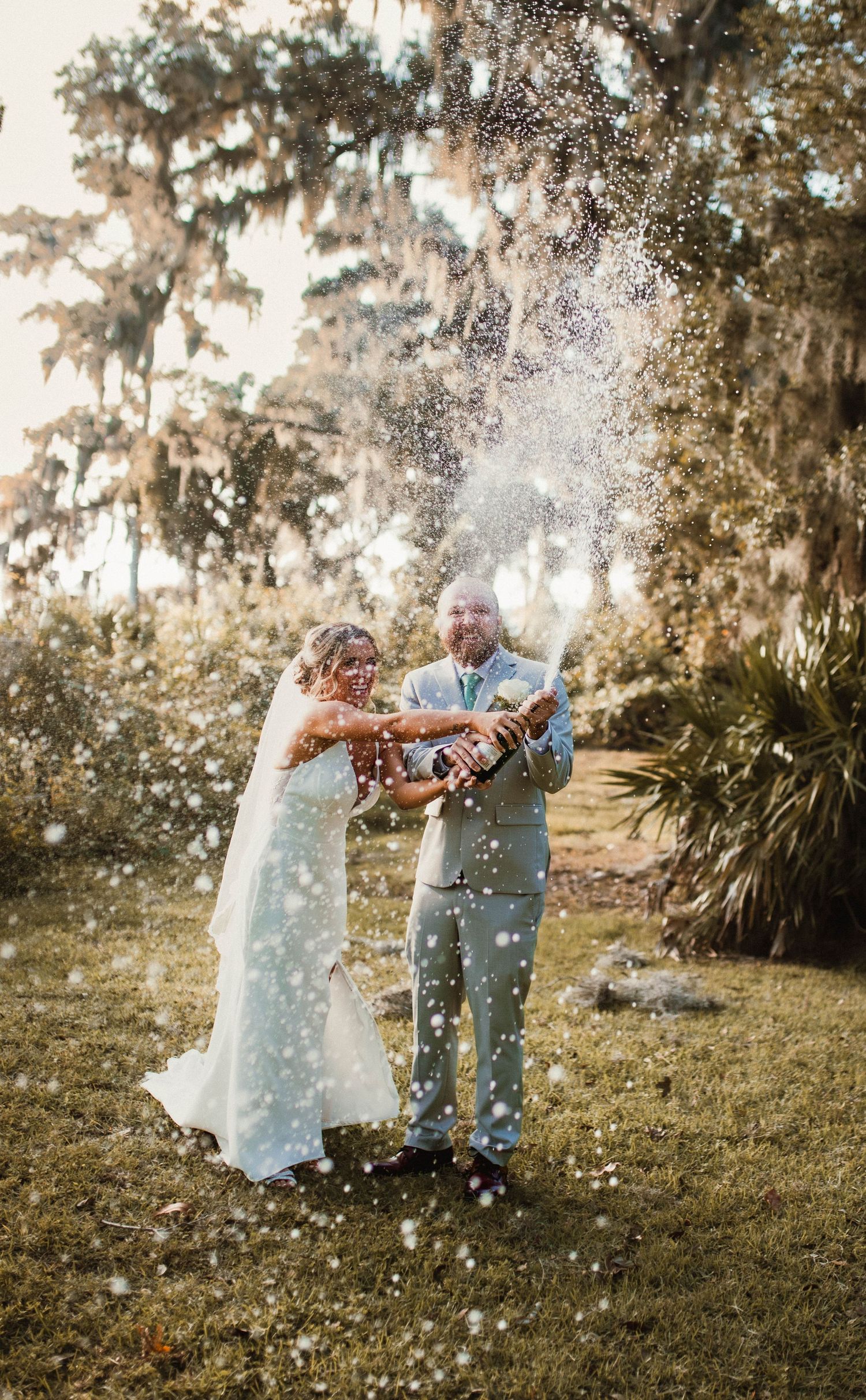Newlyweds celebrating with confetti in garden setting.