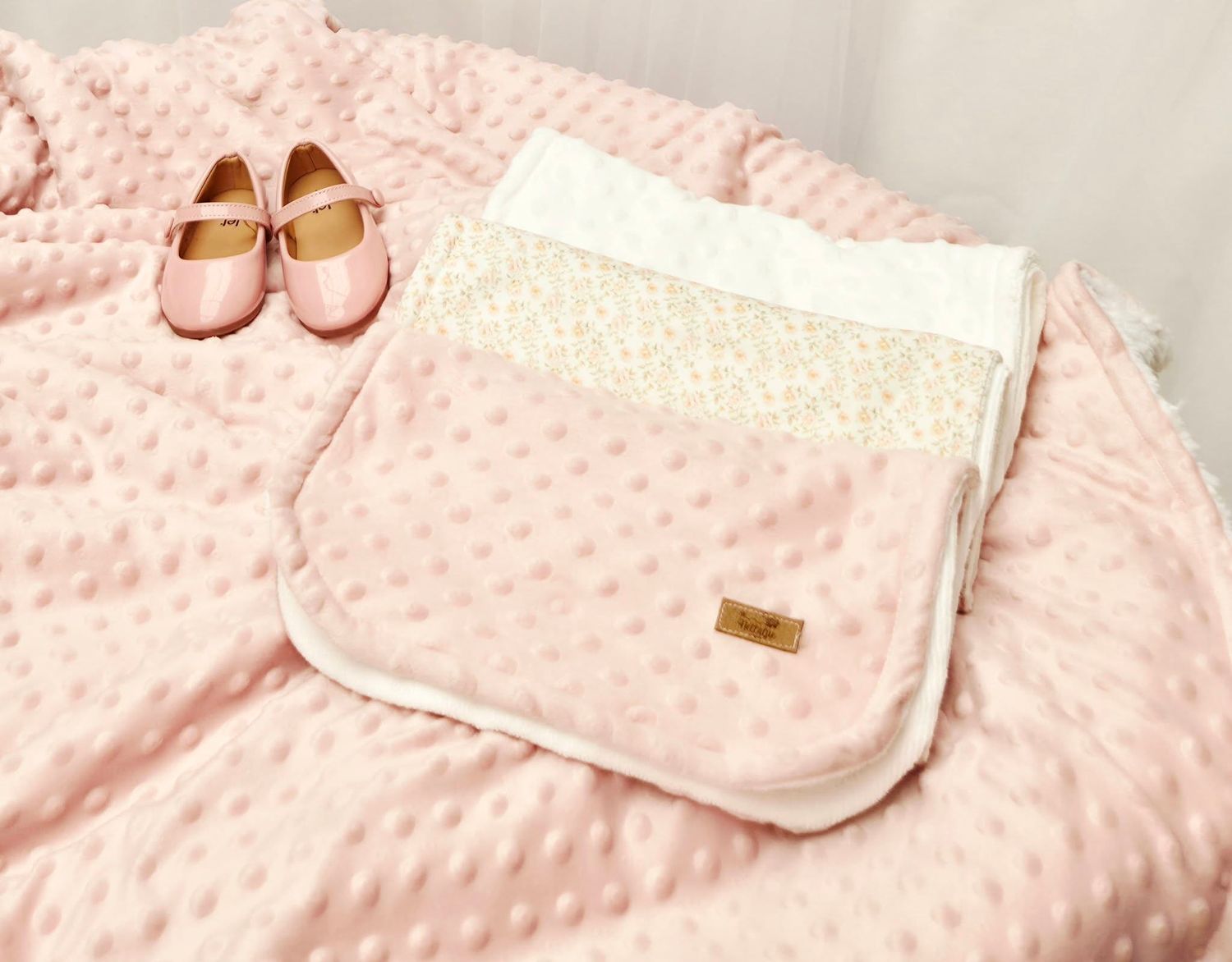 Baby blanket in shades of blue and white with polka dots and minky dot textures.