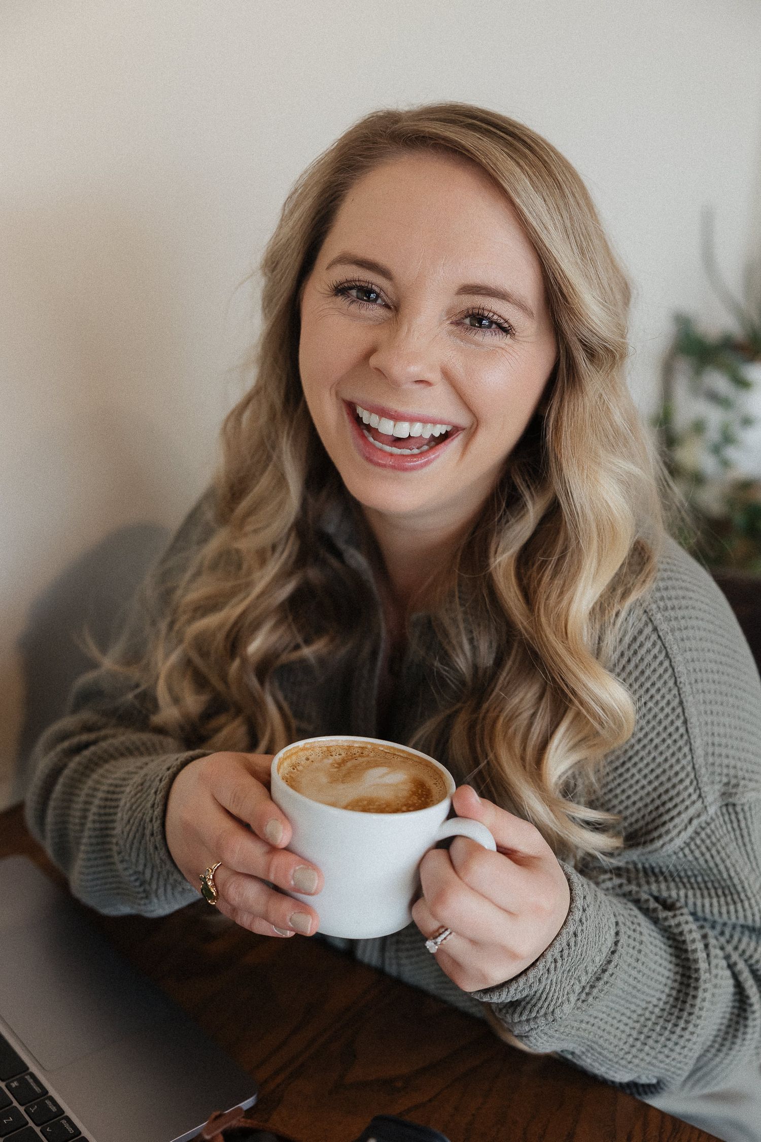 Kansas city family photographer holding a hazelnut latte in a coffee shop in lenexa kansas
