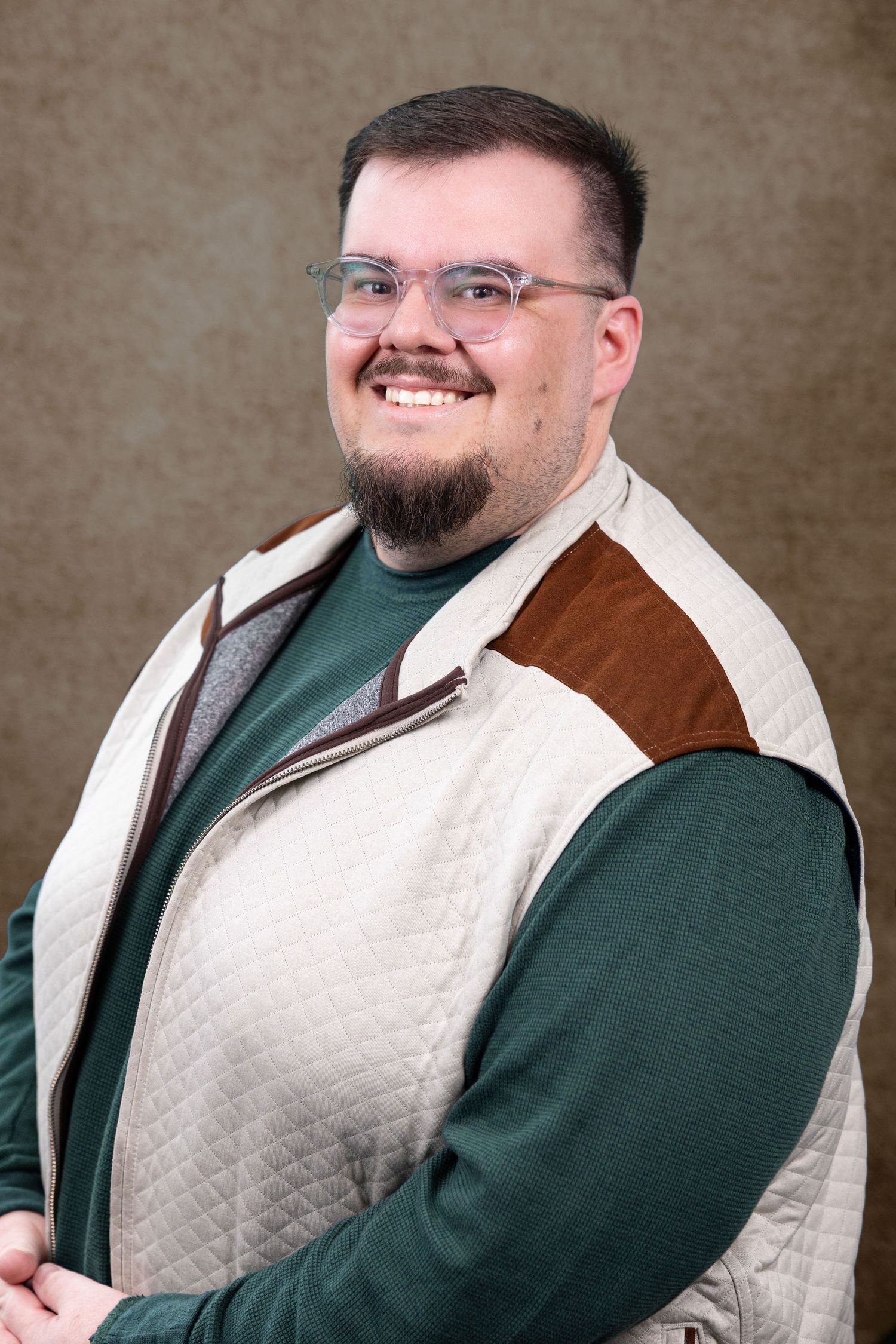 Portrait series featuring person in green sweater and white quilted vest.