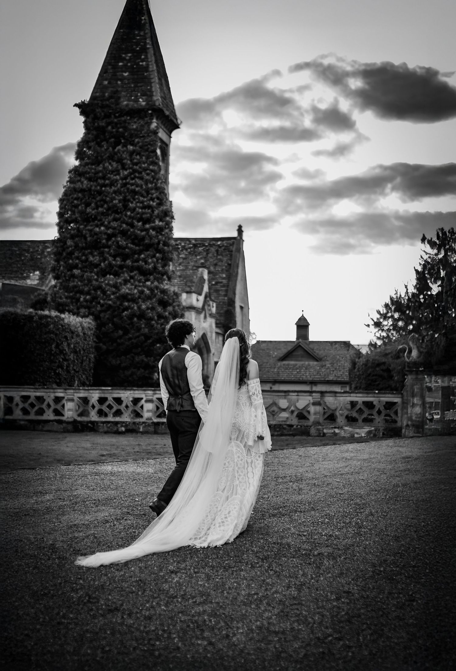 Artistic black and white photo with veil movement during an outdoor wedding portrait.