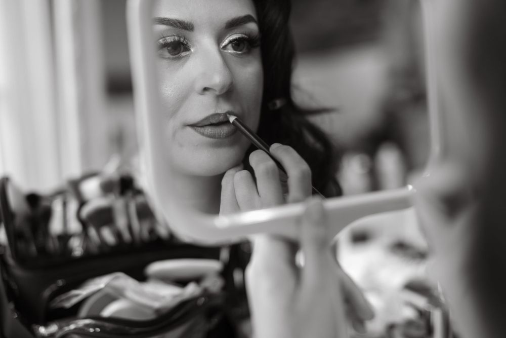 Close-up shot of bridal makeup application in black and white.