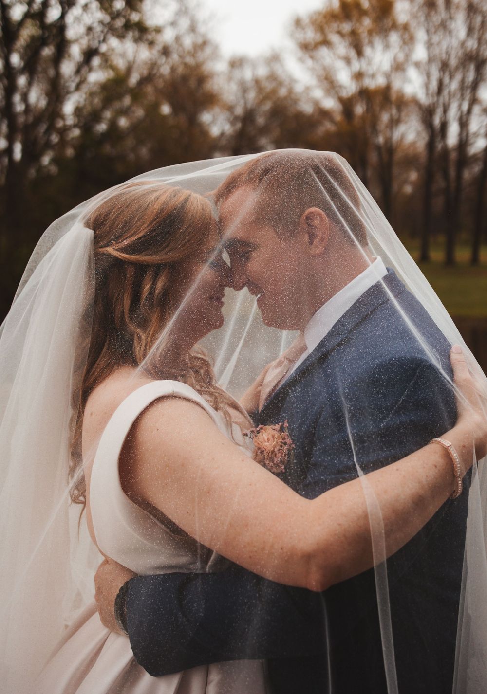 Romantic close-up shots of a couple sharing intimate moments under a wedding veil.