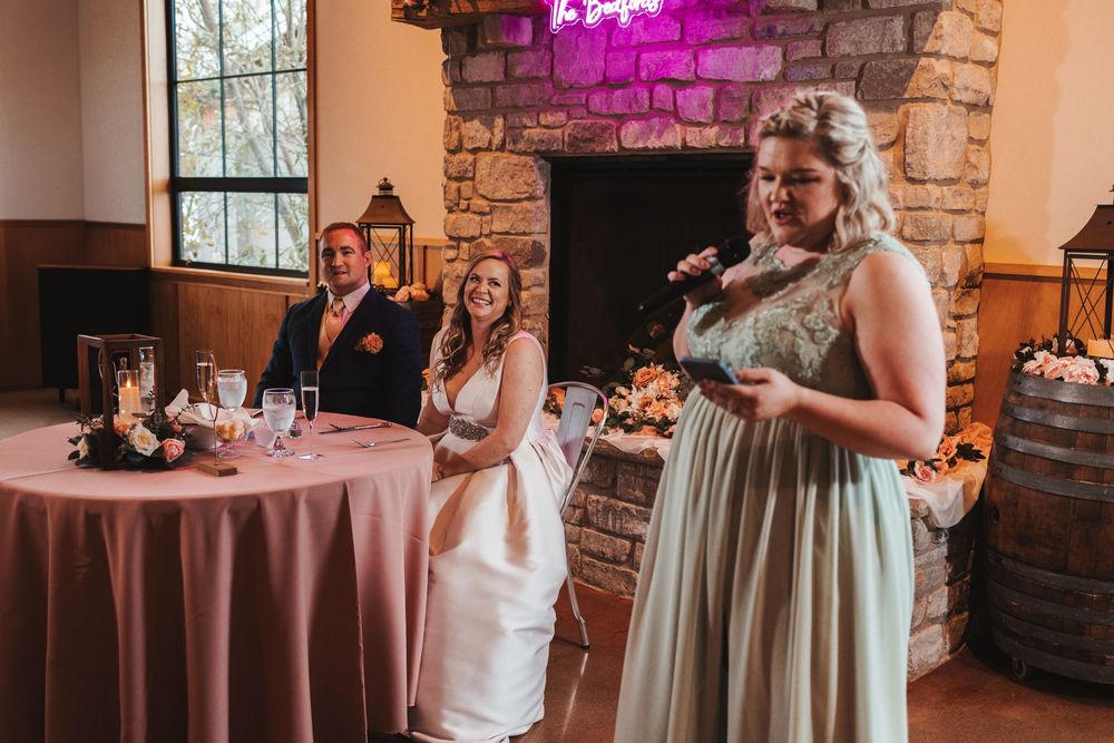Wedding reception venue with pink lighting and stone walls decorated with romantic ambiance.