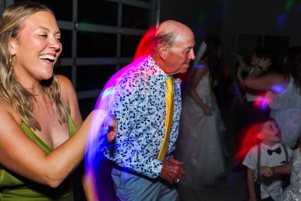 Energetic dance floor moment with guests under colorful party lights.