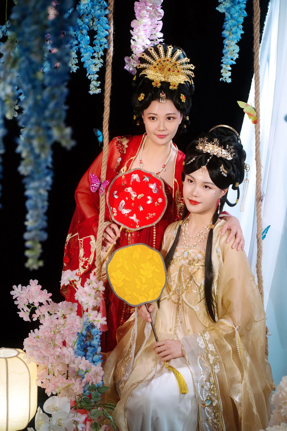 Elegant backlit studio portrait of mother and daughter in Tang Dynasty Hanfu on a swing among wisteria, by Imagine Image Studio.