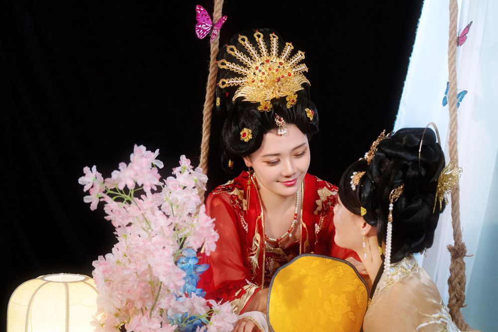 Elegant backlit studio portrait of mother and daughter in Tang Dynasty Hanfu on a swing among wisteria, by Imagine Image Studio.