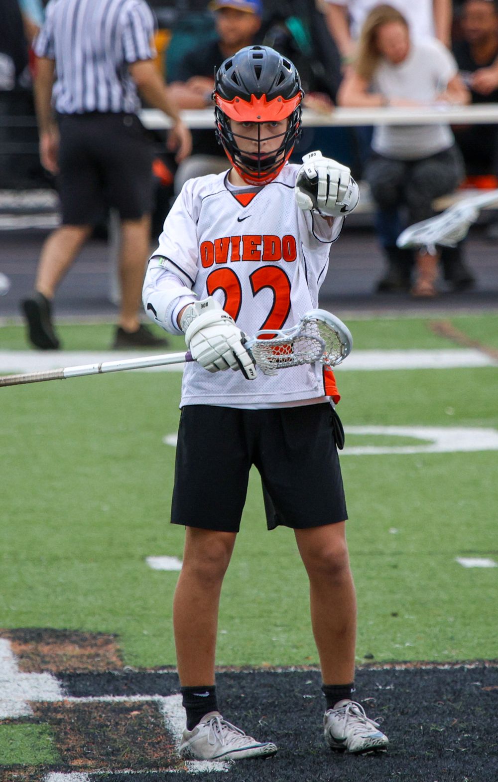 Lacrosse player in Oviedo team uniform #22 stands ready on the field during a game. Oviedo, Florida