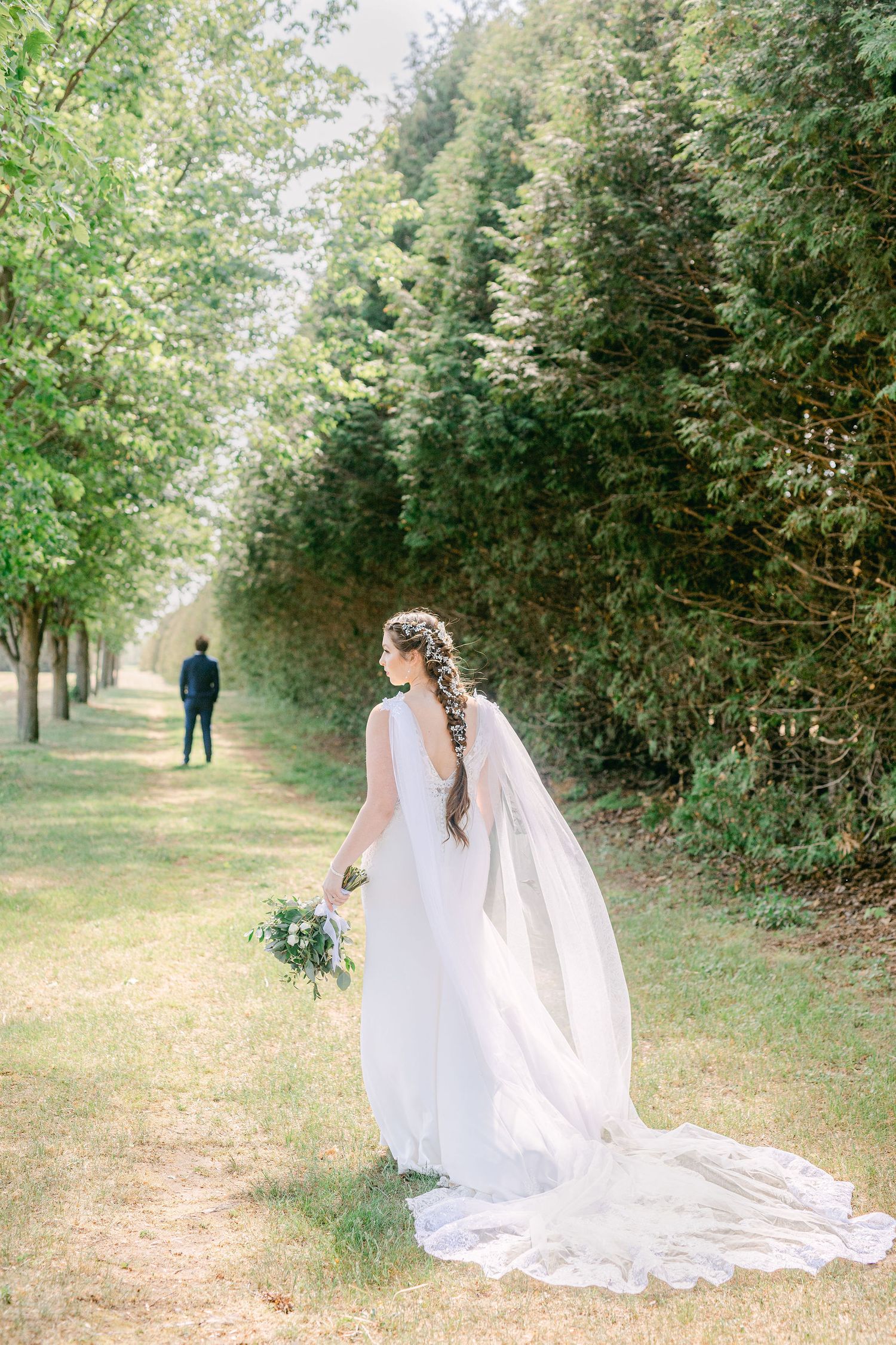 A bride and groom walking down a path captured by Katie Crane Photography at Cranberry Creek Gardens.