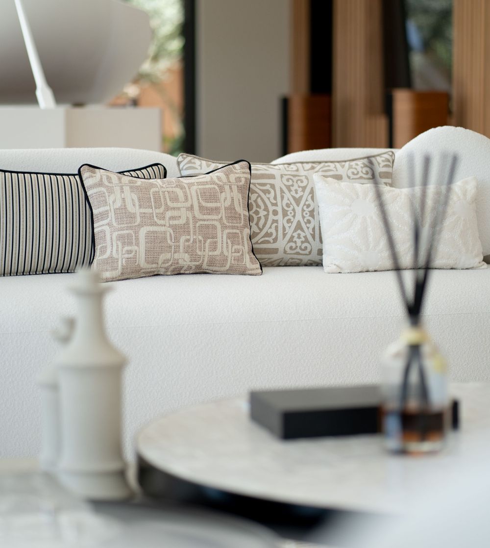 Decorative throw pillows with geometric patterns arranged on a white sofa.