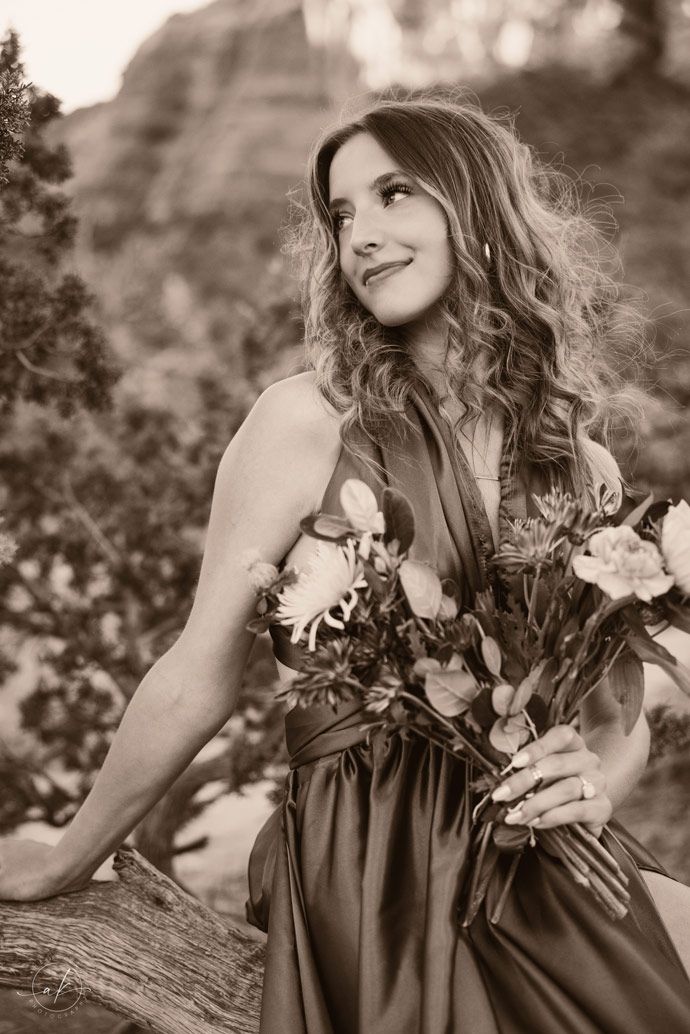 Vintage-style portrait of someone holding flowers against Sedona mountain backdrop.