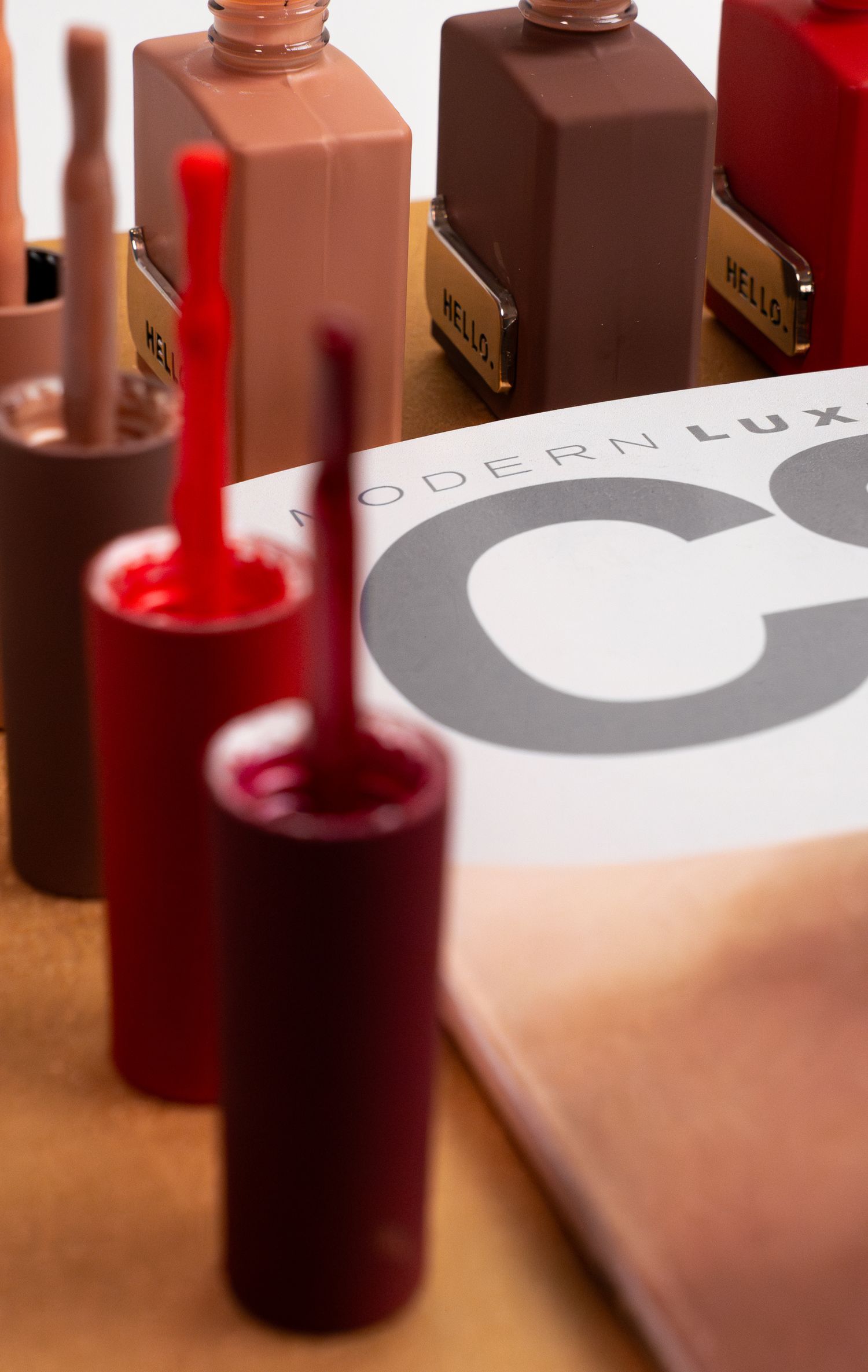 Collection of modern nail polish bottles featuring Modern Lux branding in earth tones and reds.