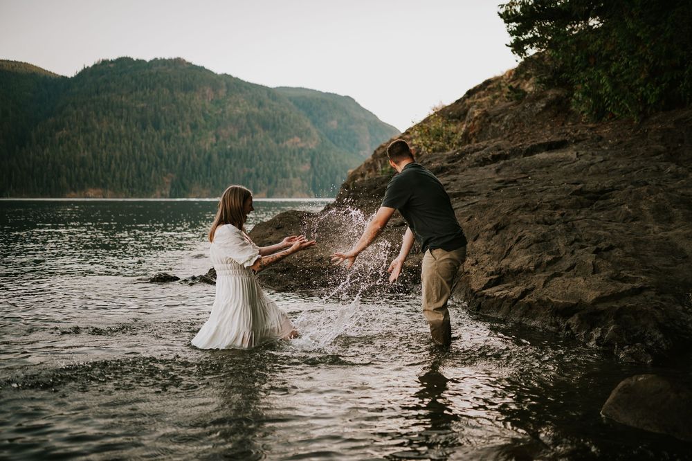 Couple adventure photography photoshoot on Vancouver Island of couple splashing water on each other in Comox Lake