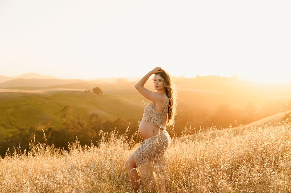 Ojai boho maternity photoshoot by Ventura Photographer, of woman in bare belly crochet meshki dress in golden field