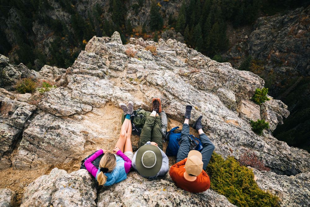 Rock climbers scale a steep limestone cliff face while secured with ropes and safety gear.