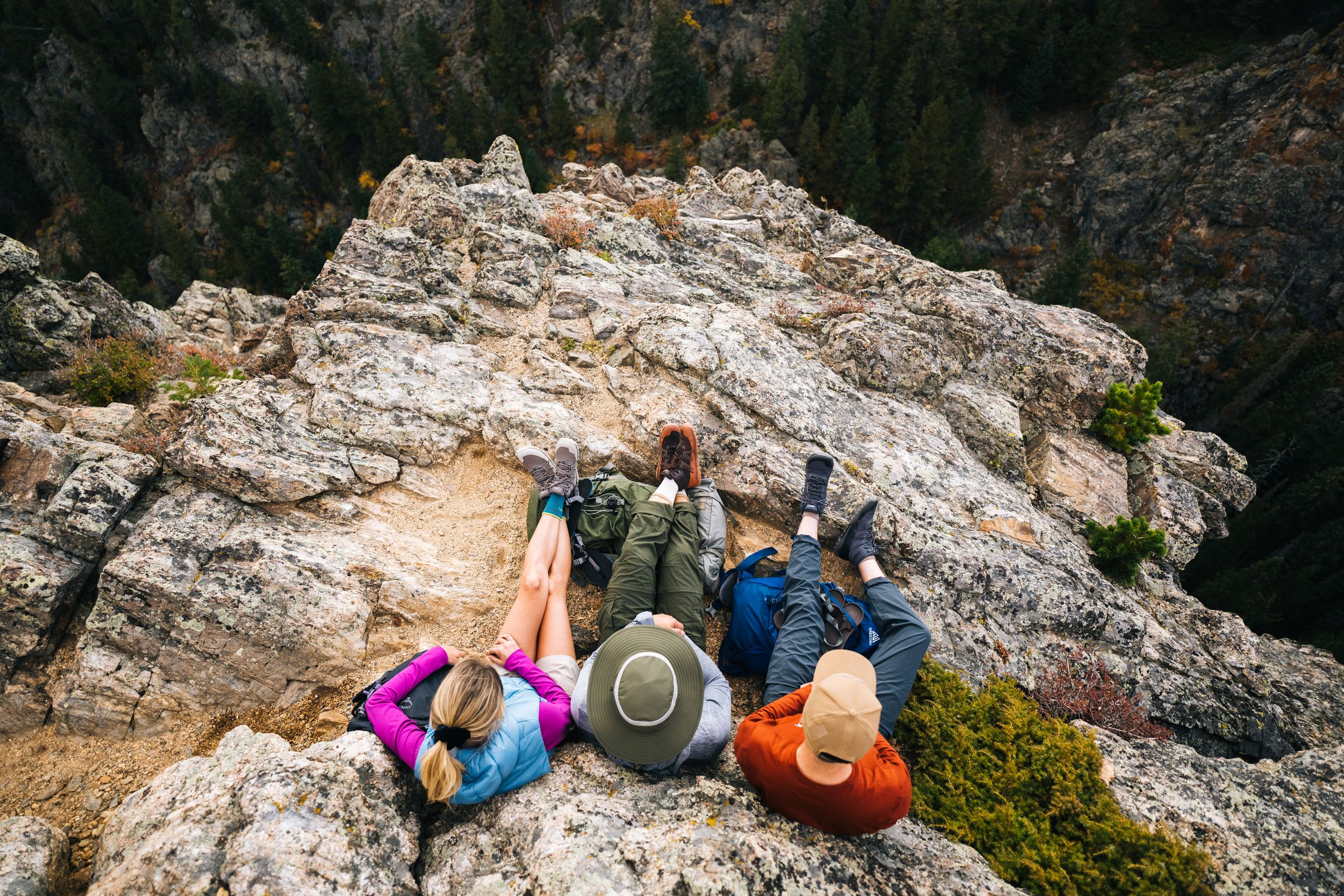 Rock climbers scale a steep limestone cliff face while secured with ropes and safety gear.