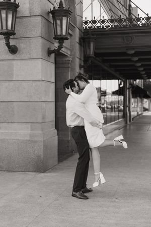 couple sharing an intimate embrace outside a historic building during a engagement portrait session