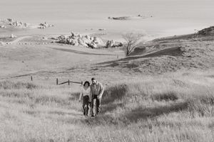 couple walking together in an open wildflower field during a couples portrait session