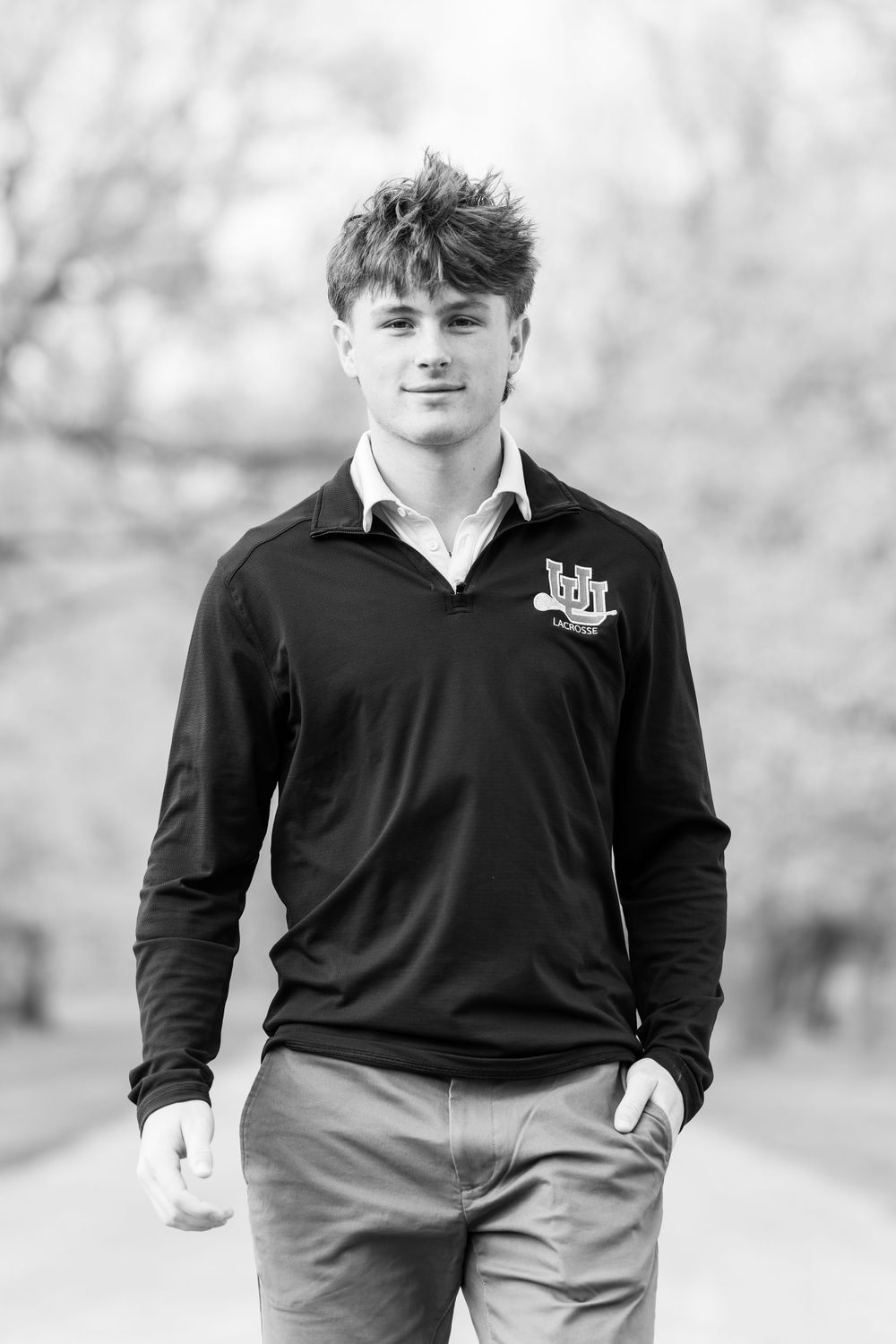 Black and white portrait of a person in polo shirt outdoors.