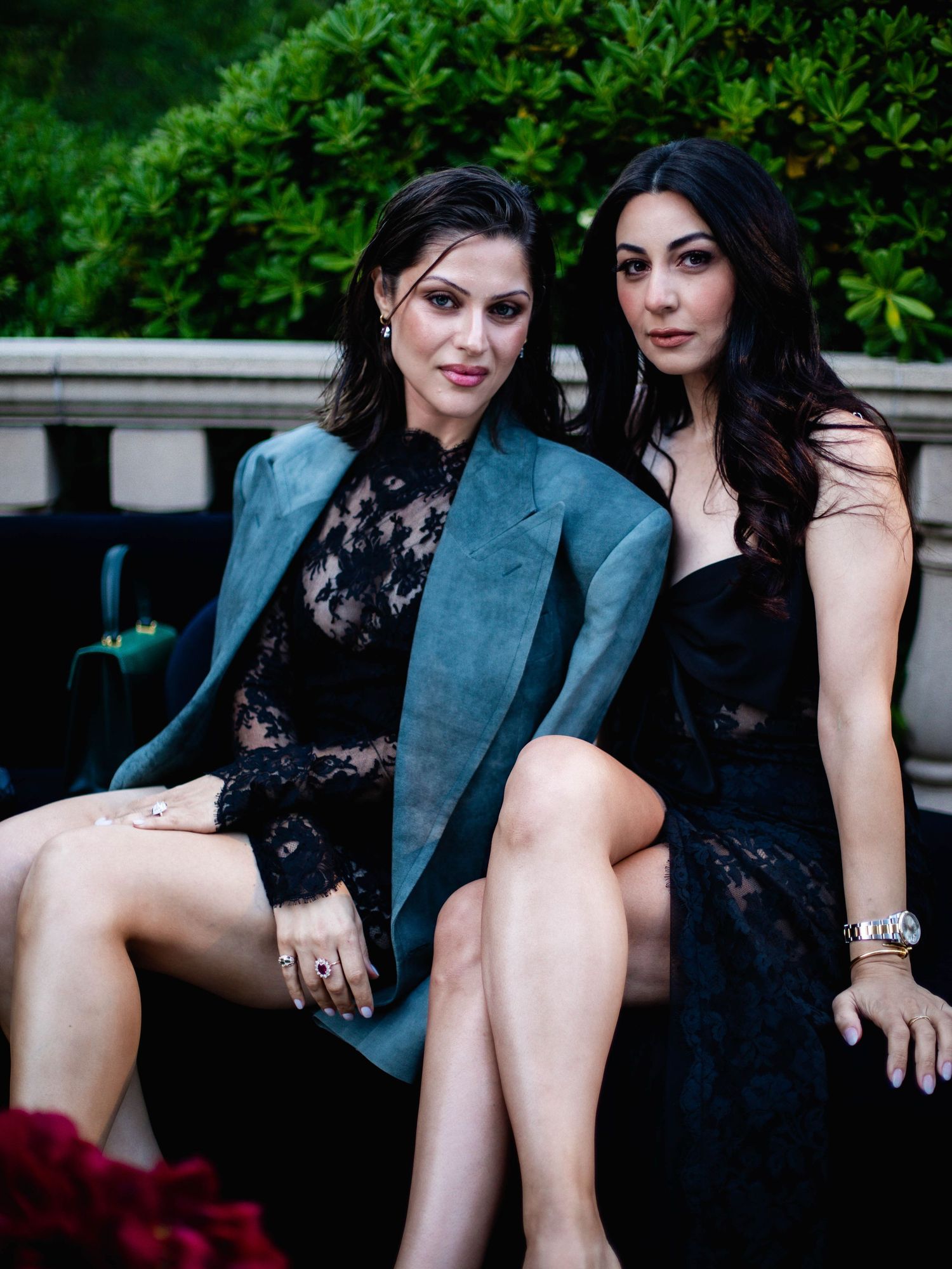 Two people in formal attire seated together on outdoor steps wearing black clothing.