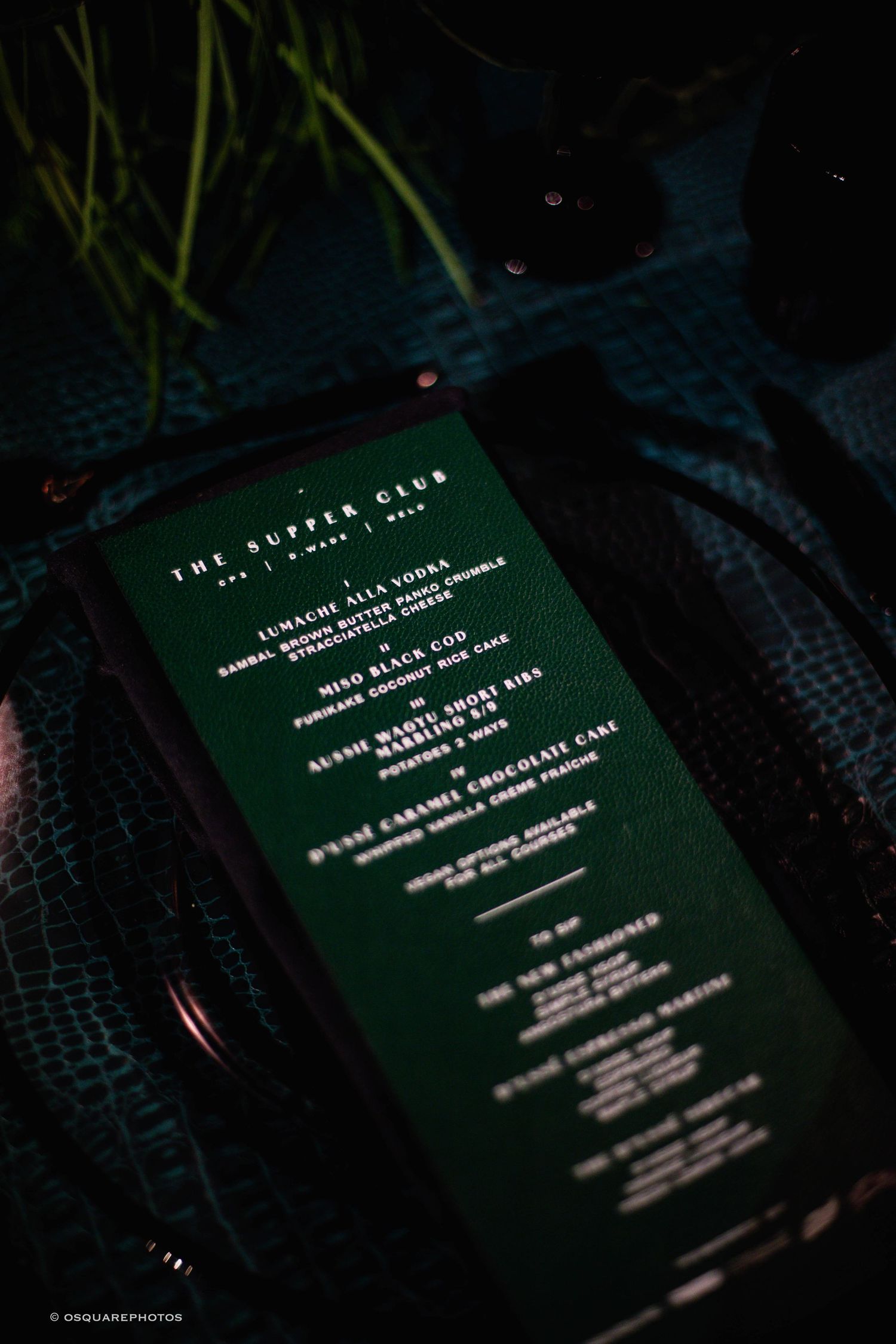 Multiple dark photos showing text on a green menu card in dim lighting.