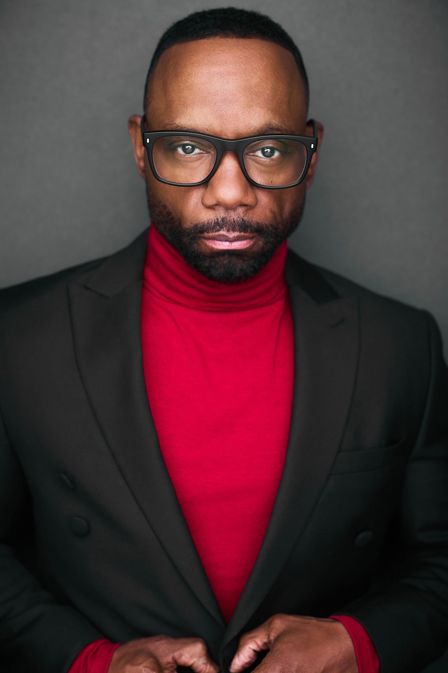 Corporate NYC headshot of a man in a red turtleneck and blazer.