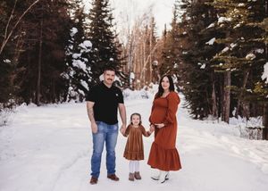 Family standing together on a snowy forest road during an outdoor family session