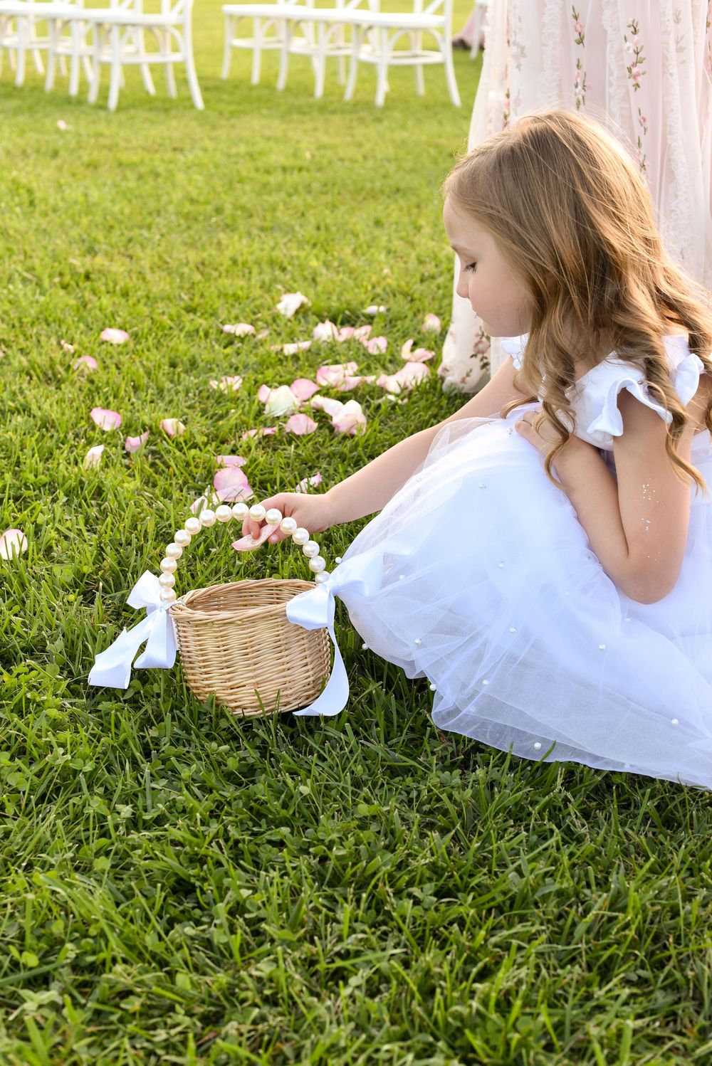 flower girl picking up petals at wedding