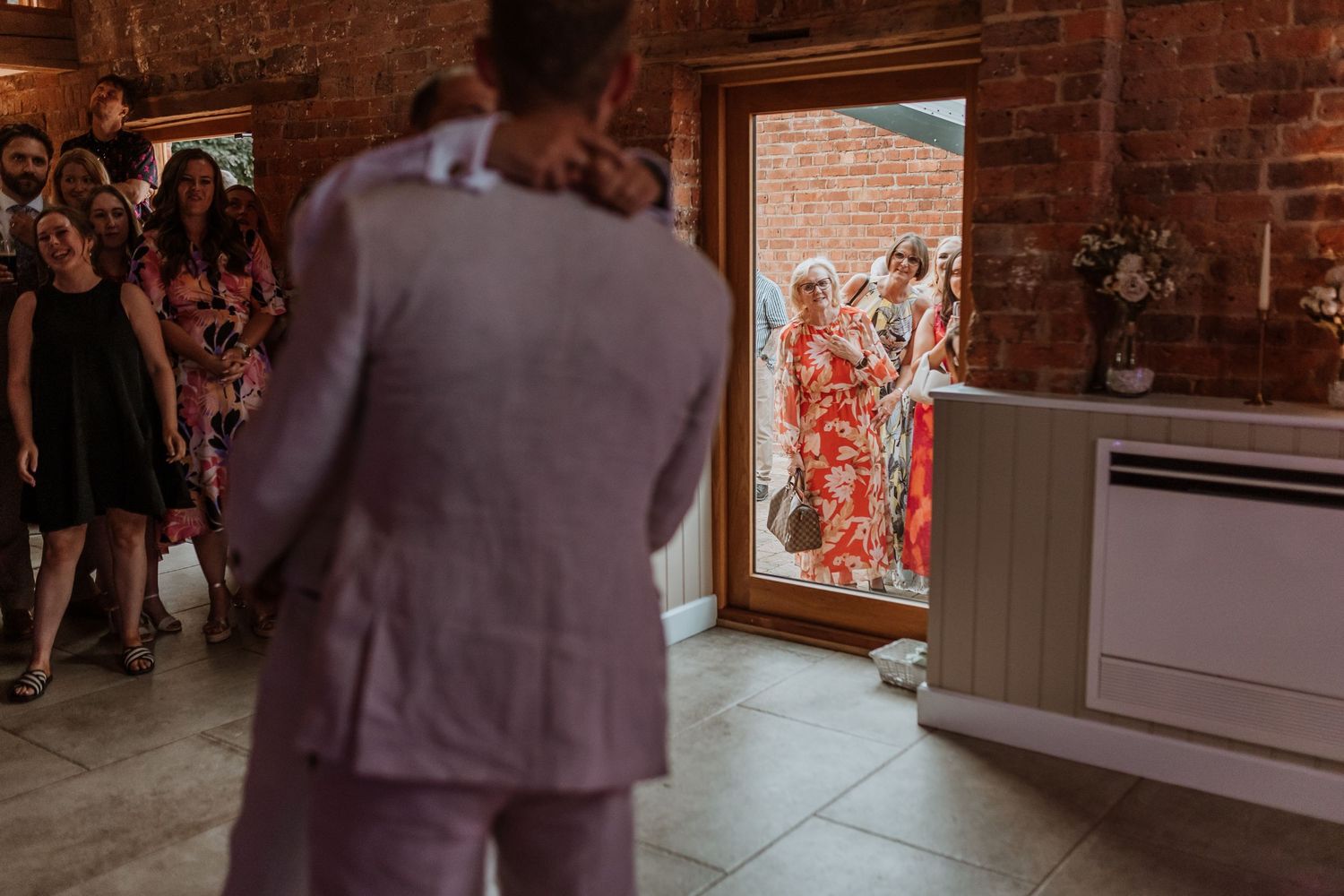Wedding guest watches first dance through window at Moat Hall Barns