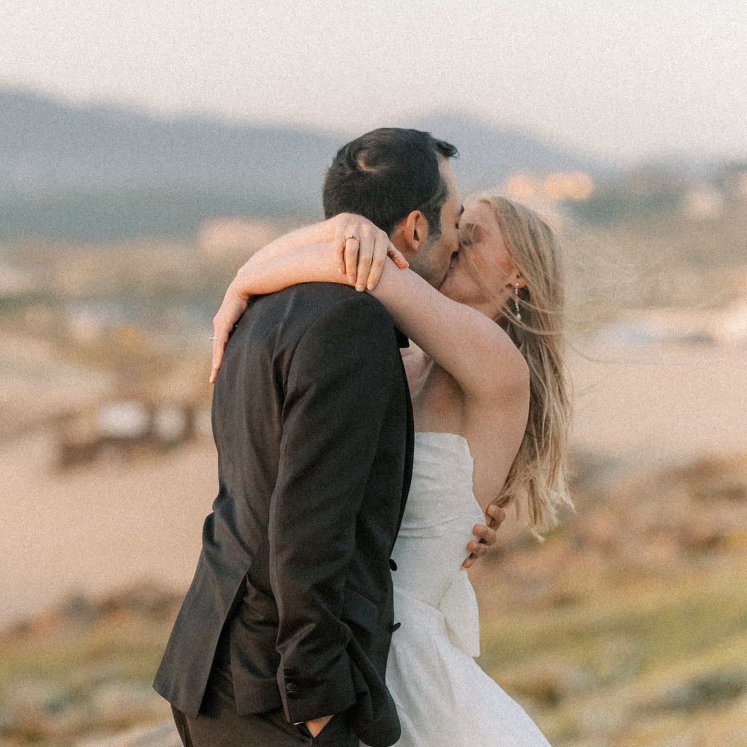 Newlyweds embracing during cinematic sunset wedding portraits on the Cascais coastline.